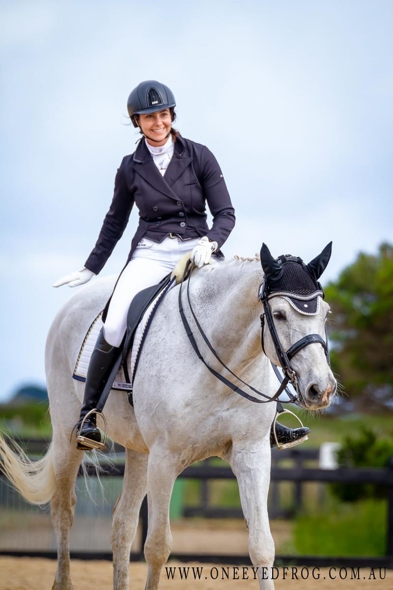 Dressage horse walking out of the arena with happy rider